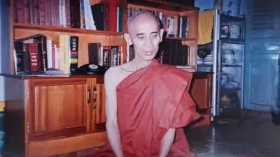 Hòa thượng Thích Tuệ Sỹ ngồi thiền trước kệ sách kinh luận nhiều ngôn ngữ